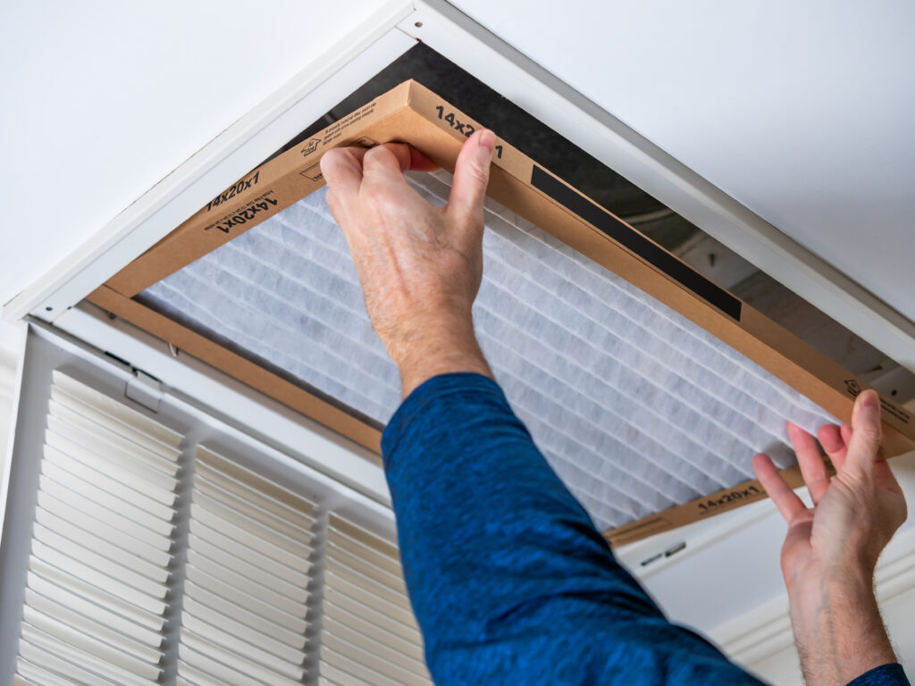 HVAC technician replacing a home air filter in Santa Maria